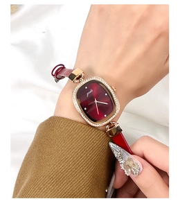 Détail de la montre carrée en or rose avec lunette diamantée et bracelet cuir rouge