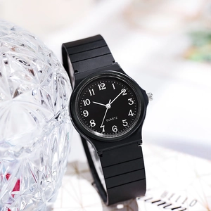 Close-up of a black minimalist quartz watch with white numerals and a textured strap