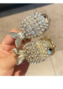 Détail de pinces à cheveux en forme de poisson avec strass étincelants en or et argent