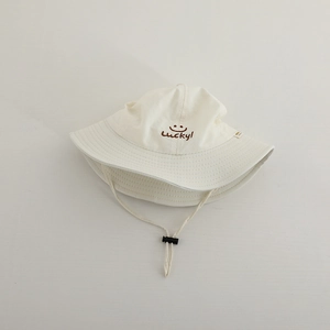 Detail of embroidered lucky smile face and adjustable drawstring on beige sun hat