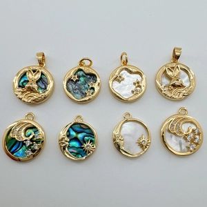 Detailed macro view of 18K gold plated charms with natural abalone shell and mother of pearl