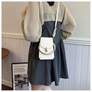 Mini white PU crossbody phone bag with adjustable strap shown on model in a minimalist setting
