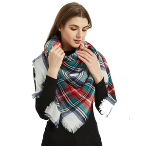Detail view of plaid scarf tassels in red, green, and blue on soft cashmere-like fabric
