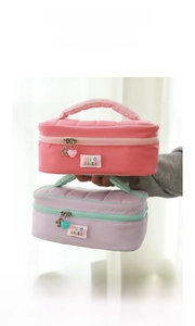 Detail view of quilted travel makeup bags in pink and purple with cute zipper charms