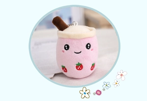Detailed close-up of a pink strawberry milk tea plush keychain with metal clasp