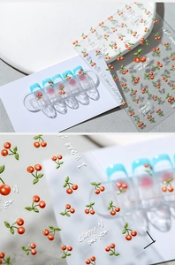 Macro shot of 3D embossed cherry nail stickers with tactile textures and cute typography