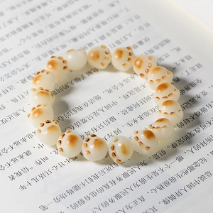 Macro detail of cat paw bead bracelet with warm burnt edge finish on open book