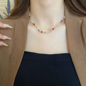 Close-up of bohemian style necklace with colorful glass beads and faceted metal spacers