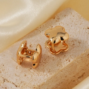 Elegant gold four-leaf clover stud earrings with a polished mirror finish on silk