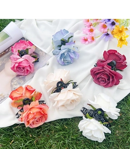 Detailed overhead view of six assorted colorful fabric rose flower hair claw clips