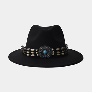 Detalle de sombrero fedora de lana negra con banda de cuentas bohemia y piedra turquesa azul