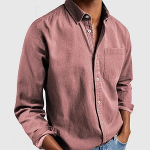 Detalle de camisa vaquera rosa polvoriento con bolsillo de pecho y textura de algodón