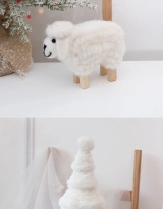 Detail of wool felt sheep figurine and cone tree decor with natural wood accents