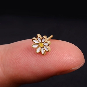 Minimalist white daisy flower stud earring in golden finish held on fingertip
