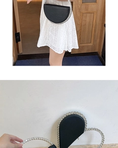 Detailed view of black crescent evening clutch with sparkling rhinestones and top handle