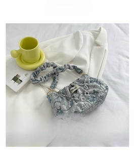 Detail of blue floral cloud bag with metal flower chain and chic pleated shoulder strap