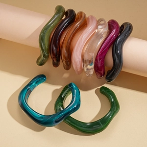Irregular geometric acrylic wave bangles in multiple marble colors on display stand