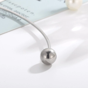 Detailed macro view of silver steel choker with metallic bead and white pearl accent