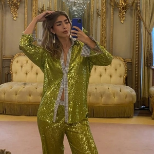 Detail of green sequin casual set featuring long sleeve shirt with plaid lining detail