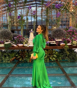 Detailed view of the elegant emerald green maxi dress featuring pleated back details