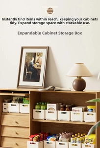 Detail of white retractable kitchen drawer organizer showing handle and storage capacity