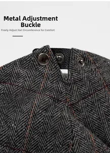Detail of adjustable metal snaps and leather strap on herringbone tweed flat cap
