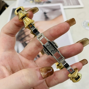 Dettaglio del cinturino dell'orologio bicolore oro e argento con chiusura in evidenza