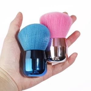 Close-up of compact mushroom head makeup brushes with colorful bristles and metallic handles
