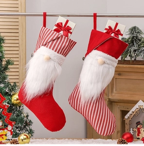 Close-up of plush Christmas gnome stockings with striped hats for holiday tree decor