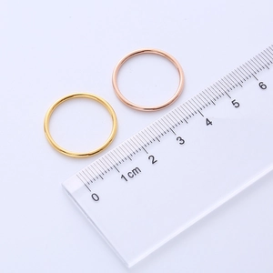 Detailed measurement of titanium steel rings in gold and rose gold with a centimeter ruler