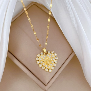 Gold heart necklace with sparkling zircon border and detailed bee motif on a twisted chain