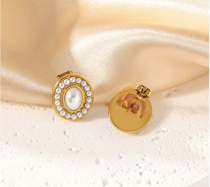 Detail view of gold vintage earrings with large central pearl and small pearl halo