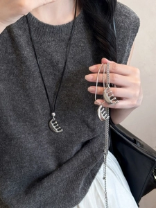 Détail du pendentif peigne en argent avec cordon en cuir et chaîne en métal sur modèle