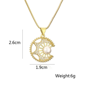 Detail view of gold sun and moon pendant with pearls and zircon, 2.6cm by 1.9cm size