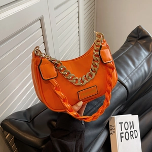Fashionable orange crescent shoulder bag with chain strap and green FASHION logo