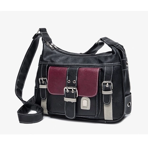 Close-up of multi-pocket saddle bag featuring black lychee leather and burgundy accents