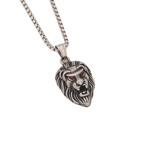 Pendentif tête de lion punk argenté avec yeux en pierre rouge sur chaîne maille