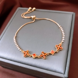 Detail of 18K gold-plated floral bracelet with orange stones and adjustable chain