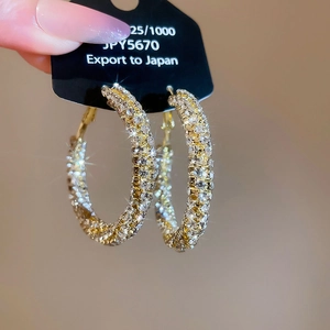 Macro shot of sparkling 925 silver hoop earrings with twisted diamond-set spiral pattern
