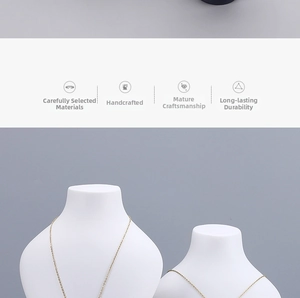 Detail of elegant gold chain necklaces displayed on two white portrait bust jewelry stands