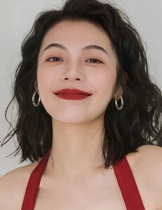 Close-up of elegant C-shaped silver earrings worn by a model in a red knit top