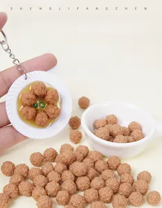 Close-up of realistic miniature beef meatballs with textured surface and pendant chain