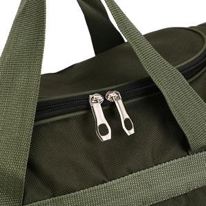 Close-up of durable dark green travel bag with sturdy silver zippers and woven handles