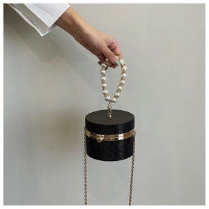 Detail of black cylindrical evening bag with pearl handle and rhinestone crystals