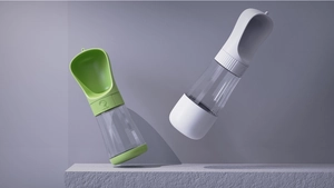 Detail of portable pet water bottle with lock button on a textured stone platform