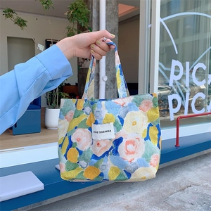 Gros plan d'un sac en toile aux fleurs style peinture à l'huile avec étiquette tissée