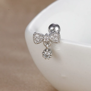 Détail de piercing hélix papillon en acier argenté avec incrustations de zircon
