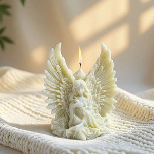 3D angel wing scented candle with intricate feather texture on white knit background