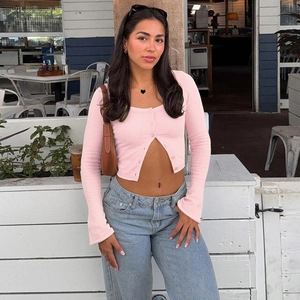 Pink cropped cardigan with U-neck and buttons paired with high-waisted wide-leg jeans