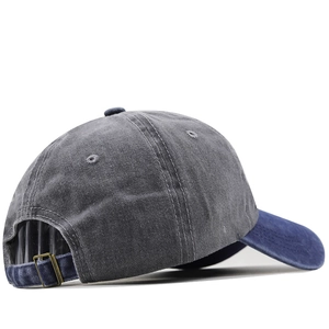 Detail view of vintage washed baseball cap with contrast brim and adjustable bronze buckle